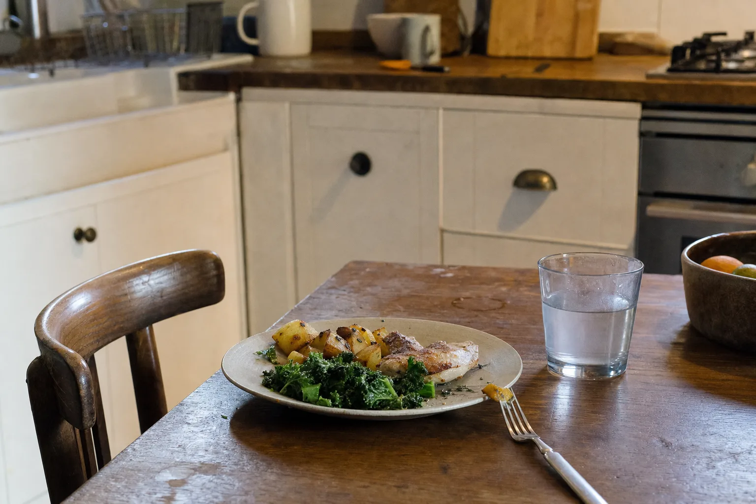 One simple dinner plated on a table set for one in warm evening light